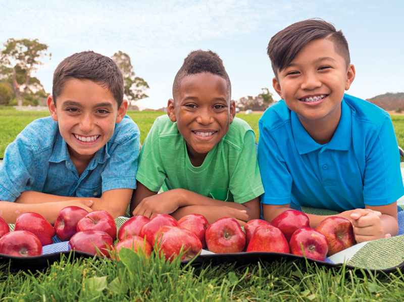 three boys with apples